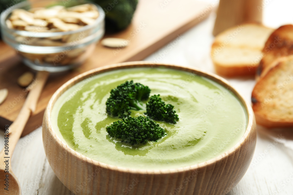 Delicious broccoli cream soup served on white wooden table, closeup Delicious broccoli cream soup served on white wooden table, closeup