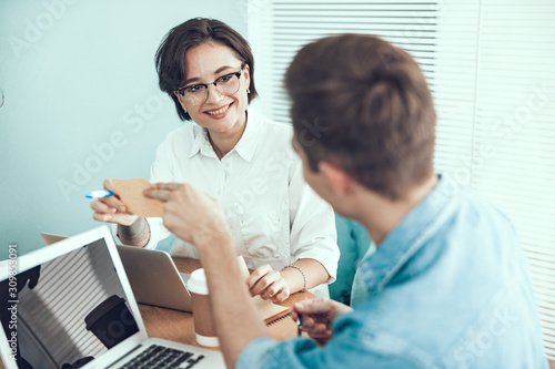 Young man is sitting near female colleague