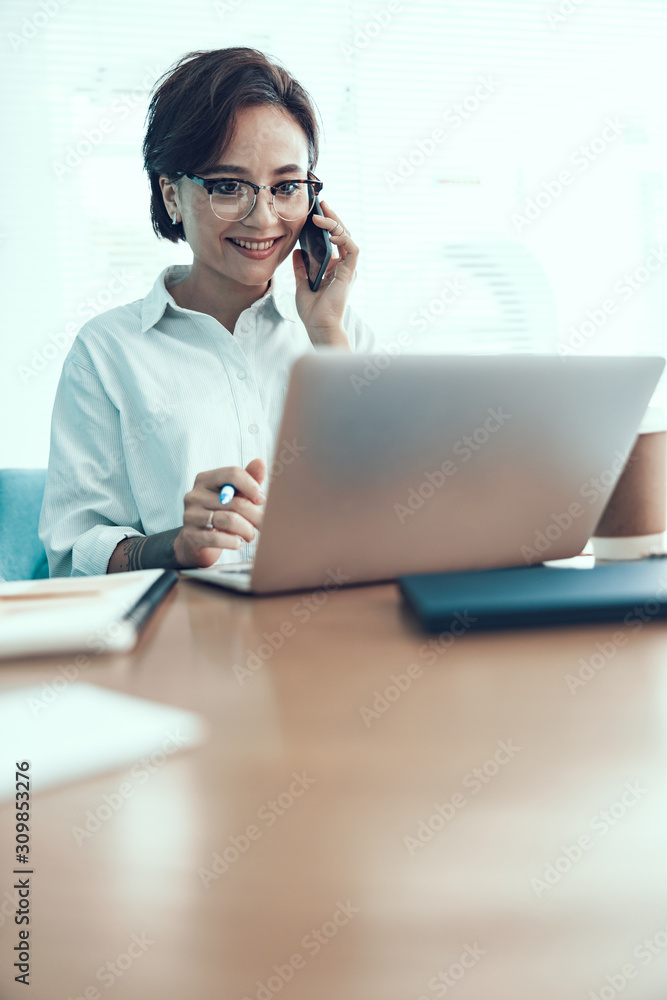 Smiling young woman talking on mobile phone Smiling young woman talking on mobile phone