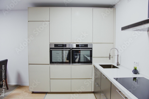 minimalistic kitchen interior, sink, oven, stove, range hood close up 