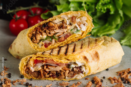 Shawarma sandwich gyro fresh roll of lavash pita bread chicken beef shawarma falafel RecipeTin Eatsfilled with grilled meat, mushrooms, cheese. Traditional Middle Eastern snack. On wooden background photo