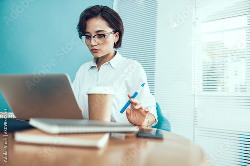 Young woman in glasses working in office