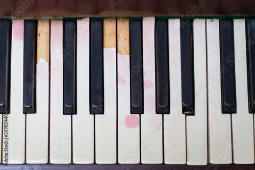 Aged piano with dirty keys and wine