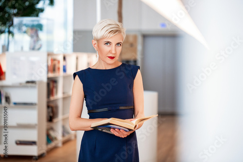 Fotografía Charming mid age lady reads a book in the application