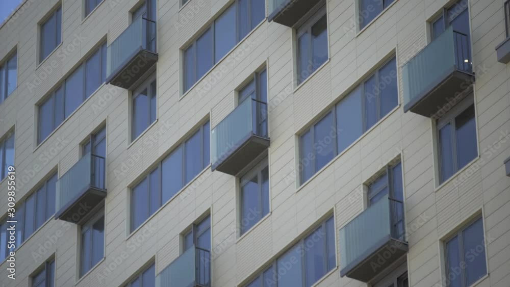 Close up shot of residential building. Close up Of An Apartment Blocks. The building features exterior with small balconies Close up shot of residential building. Close up Of An Apartment Blocks. The building features exterior with small balconies
