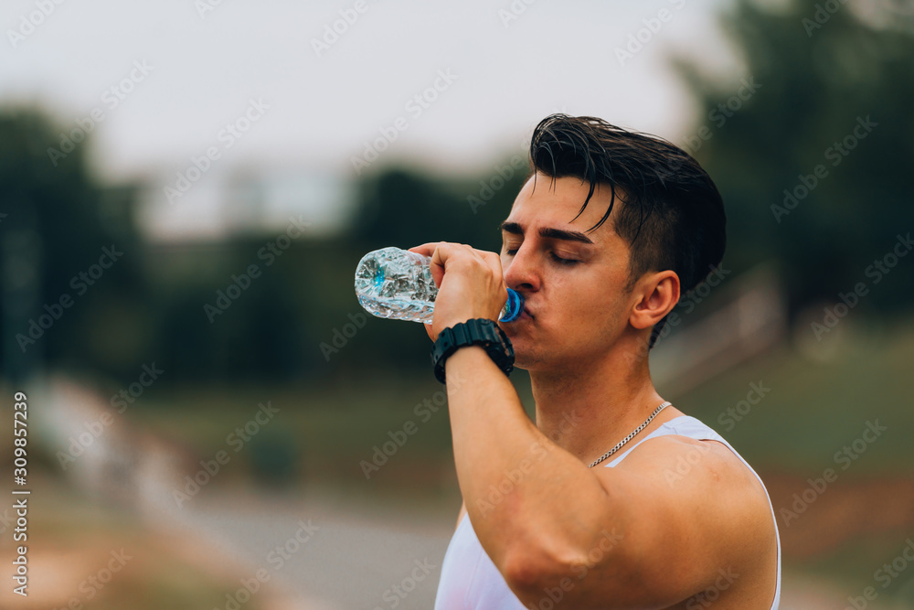 A man drinking water during his exercise A man drinking water during his exercise