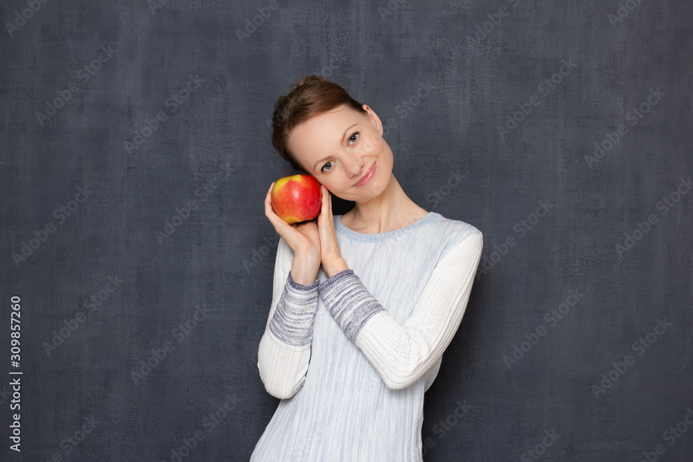 Portrait of happy girl smiling and holding ripe apple in hands Portrait of happy girl smiling and holding ripe apple in hands