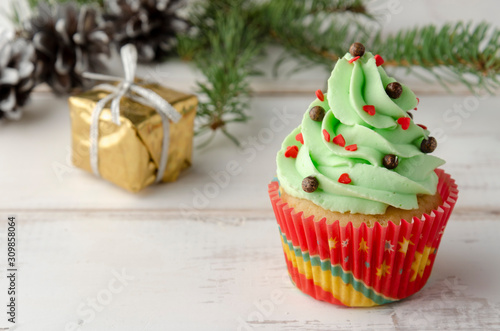 christmas green cupcake with whipped cream, decorated with christmas tree