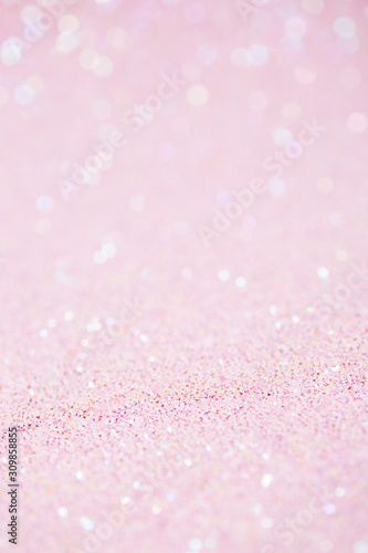 Vertical pink background with closeup light sparkling glitter texture
