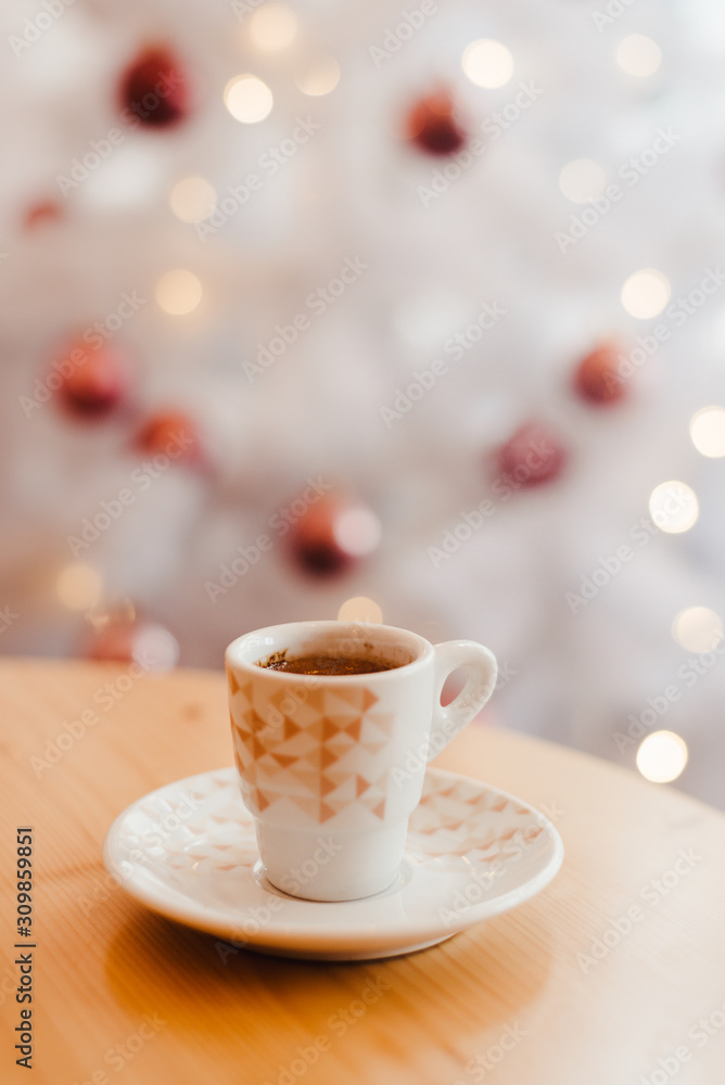 Cup of espresso or short coffee in white cup in cosy Christmas arrangement, festive decoration with white bokeh background, copy space Cup of espresso or short coffee in white cup in cosy Christmas arrangement, festive decoration with white bokeh background, copy space