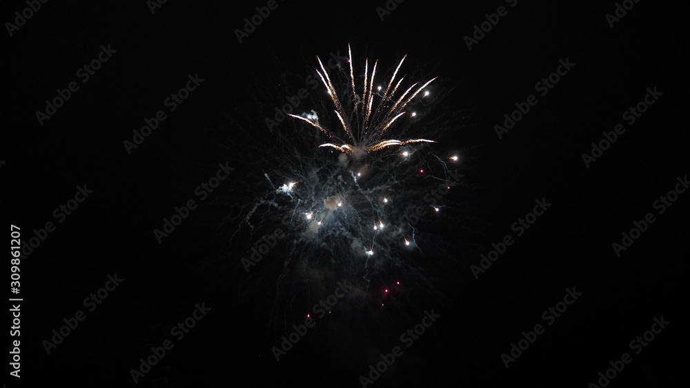 beautiful multi colored fireworks in night sky. New year's eve fireworks celebration. shining fireworks with bokeh lights in night sky. glowing fireworks show. colored night explosions in black sky
