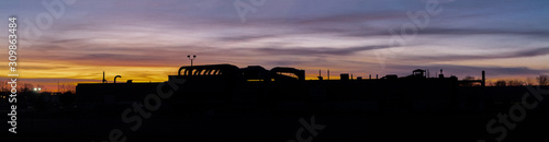 Silhouette of an industrial plant at sunset