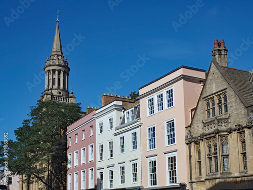 Oxford High Street,with the facades of commercial buildings among Oxford University buildings, and the spire of All Saints Church photo