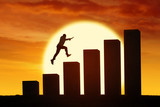 Silhouette of businessman jumping through chart