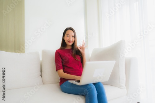 Portrait beautiful young asian women using computer laptop on sofa chair