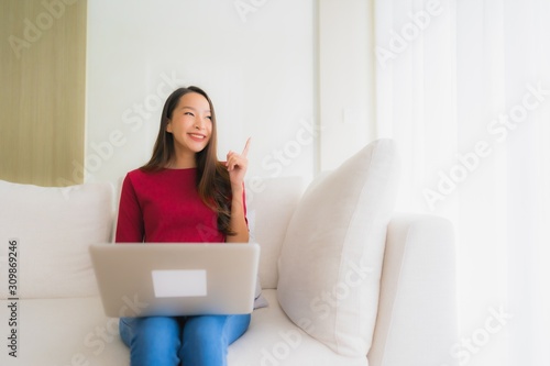 Portrait beautiful young asian women using computer laptop on sofa chair