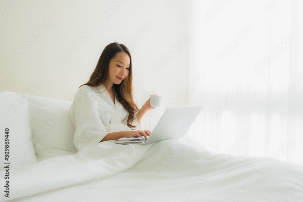 Portrait beautiful young asian women with coffee cup and computer laptop on bed Portrait beautiful young asian women with coffee cup and computer laptop on bed