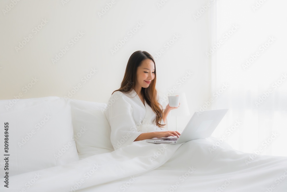 Portrait beautiful young asian women with coffee cup and computer laptop on bed Portrait beautiful young asian women with coffee cup and computer laptop on bed