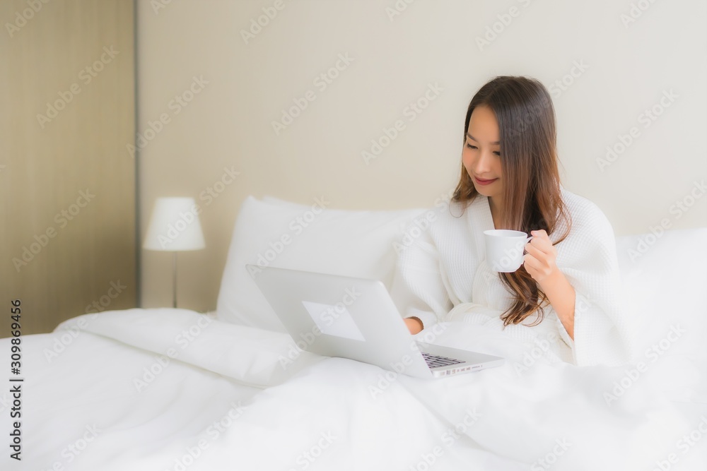 Portrait beautiful young asian women with coffee cup and computer laptop on bed Portrait beautiful young asian women with coffee cup and computer laptop on bed
