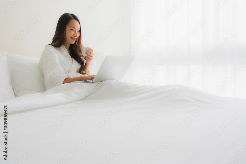 Portrait beautiful young asian women with coffee cup and computer laptop on bed Portrait beautiful young asian women with coffee cup and computer laptop on bed