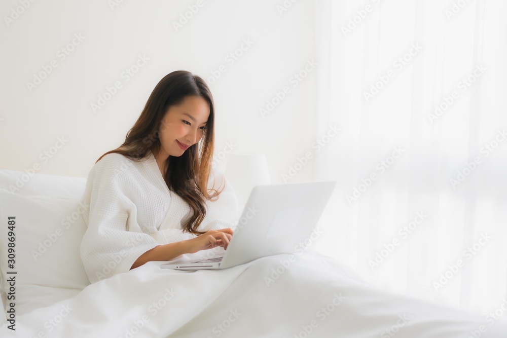 Portrait beautiful young asian women with coffee cup and computer laptop on bed Portrait beautiful young asian women with coffee cup and computer laptop on bed