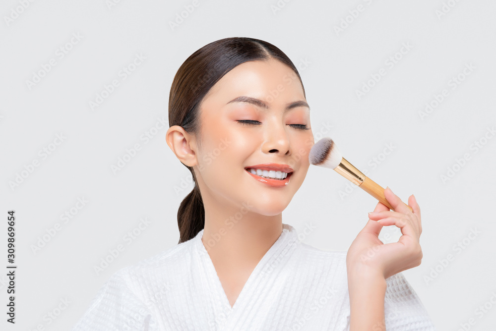 Beauty shot of young Asian woman applying blush on her face Beauty shot of young Asian woman applying blush on her face