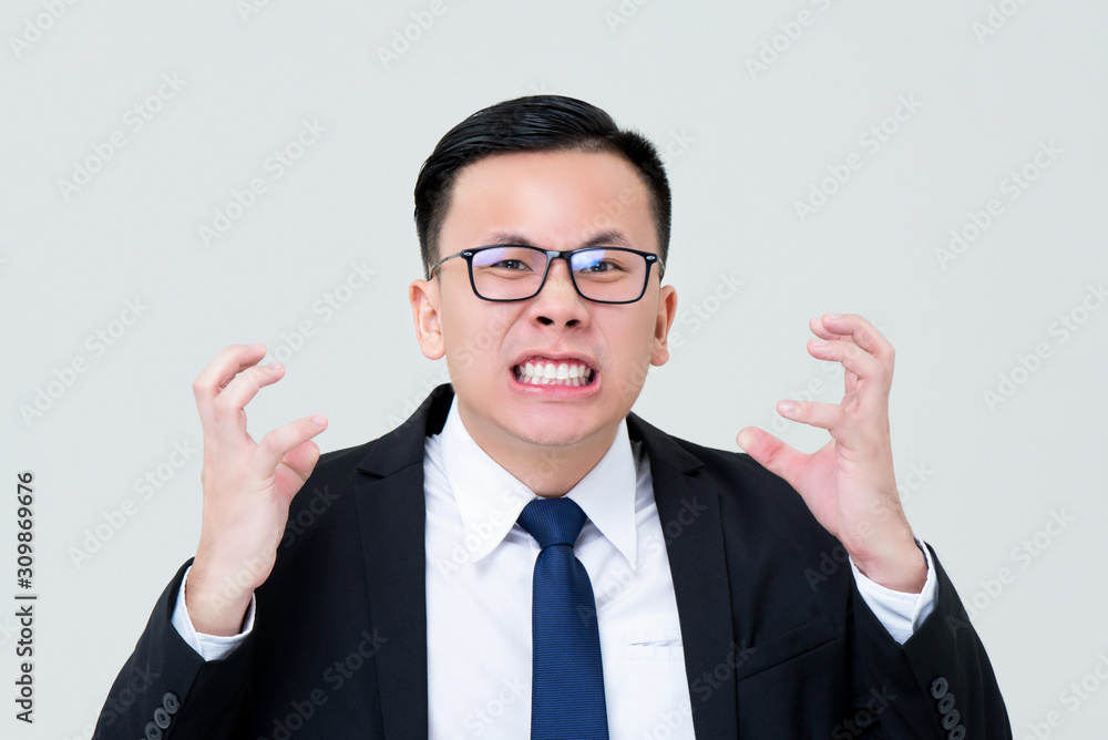Grinning Asian businessman feeling angry with hands squeezing Grinning Asian businessman feeling angry with hands squeezing