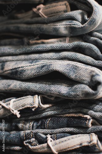 jeans stacked ina apile. Jeans in shop stacked in a neat pile for customers. Light blue, dark background