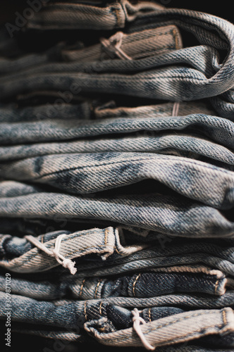 jeans stacked ina apile. Jeans in shop stacked in a neat pile for customers. Light blue, dark background