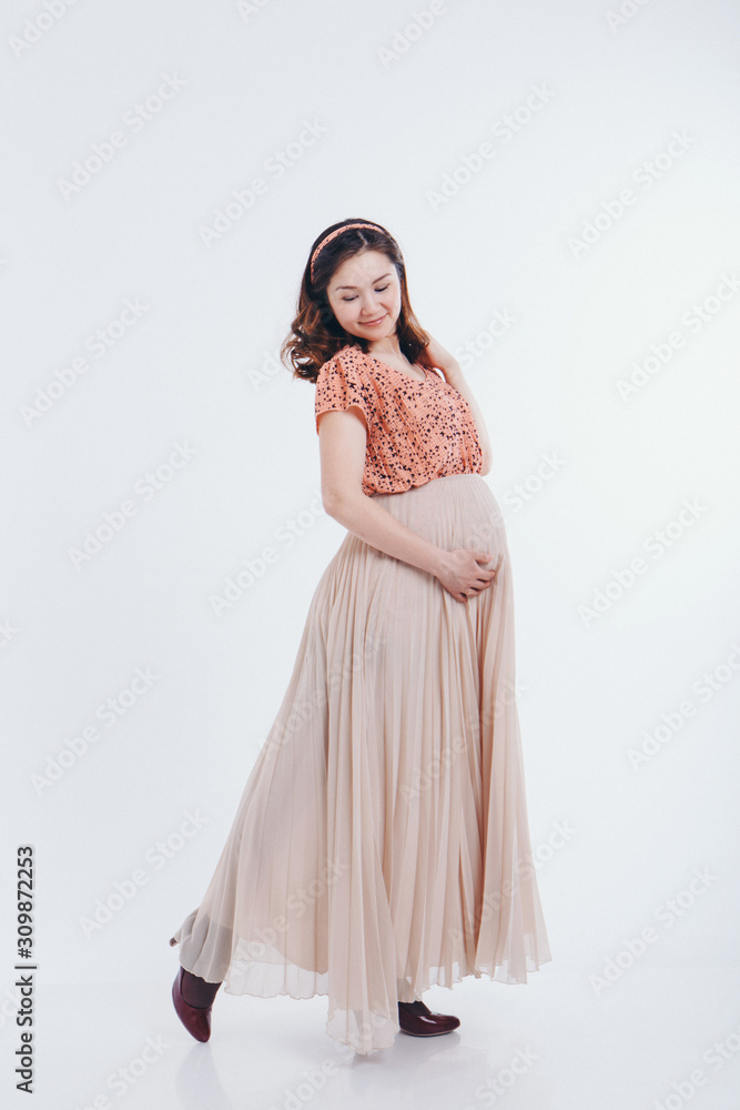 pregnant woman stroking her belly on white background. Copy space. The concept of healthy digestion, lifestyle, IVF pregnant woman stroking her belly on white background. Copy space. The concept of healthy digestion, lifestyle, IVF
