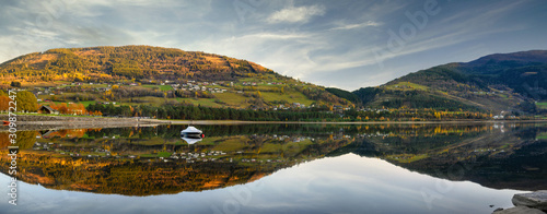 Panoramic view boat floats on the water, with a mountain as a background, reflecting the clear and calm water like a mirror in Voss, Norway.