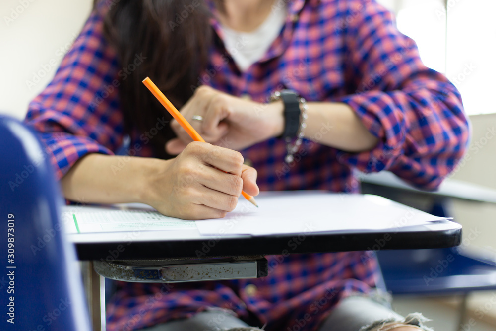 high school,university student study.hands holding pencil writing paper answer sheet.sitting lecture chair taking final exam attending in examination classroom.concept scholarship for education abroad high school,university student study.hands holding pencil writing paper answer sheet.sitting lecture chair taking final exam attending in examination classroom.concept scholarship for education abroad