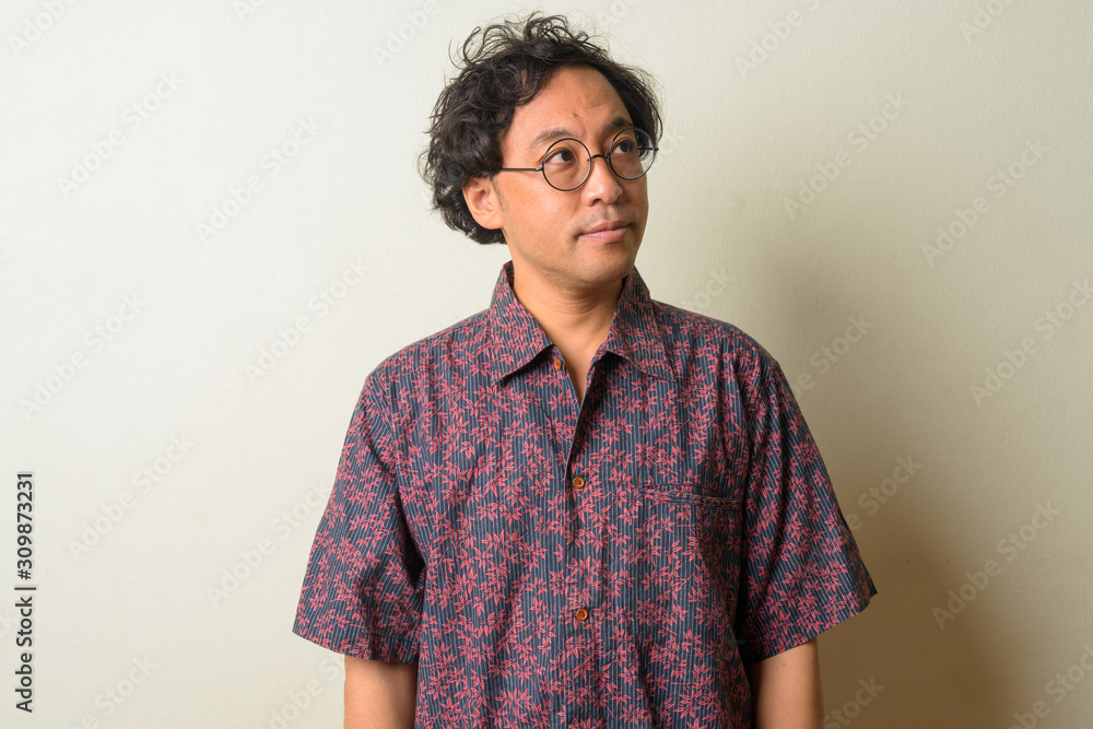 Portrait of Japanese man with curly hair thinking Portrait of Japanese man with curly hair thinking