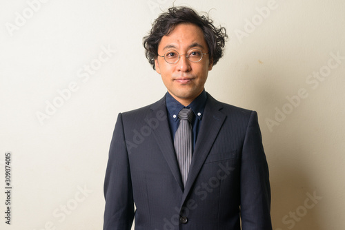Face of Japanese businessman in suit with curly hair