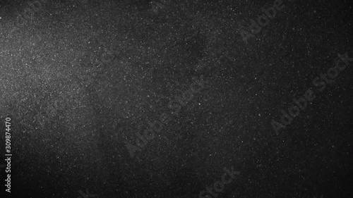Natural Organic Dust Particles Floating On Black Background. Glittering Sparkling Particles Randomly Spin In The Air With Bokeh. Dynamic Particles With Fast And Slow Motion. Shimmering Dust In Space.