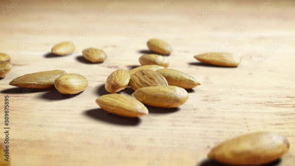 Close Up of Almonds Tossed from Side on Wooden Table. Handful of Nuts Rolling and Stopping on Flat Surface. Healthy Diet Superfood. Close Up of Almonds Tossed from Side on Wooden Table. Handful of Nuts Rolling and Stopping on Flat Surface. Healthy Diet Superfood.
