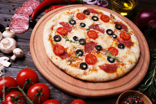 Italian pizza with the best products, with tomatoes, mozzarella cheese, mushrooms and olives,salami