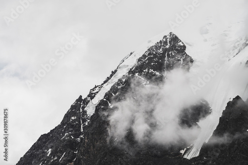 Schilderij op canvas Atmospheric minimalist alpine landscape with hanging glacier on snowy rocky mountain peak