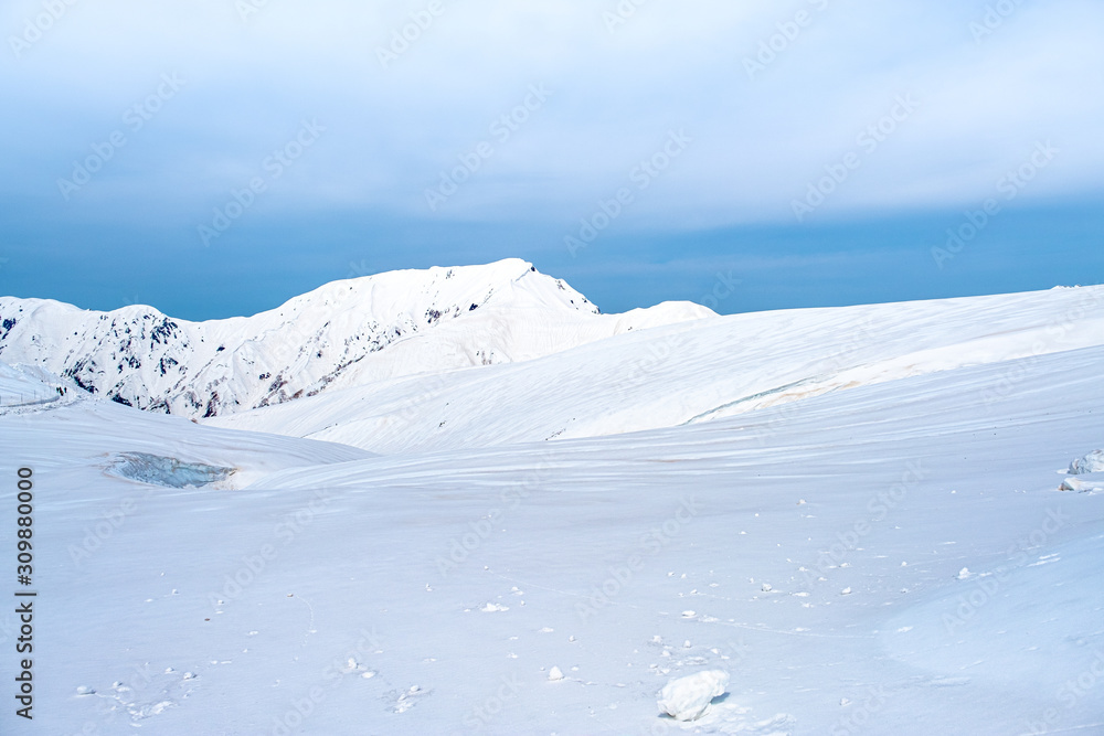 Close up top of white snow mountain view, snow covered beautiful landscape on blue sky background.Famous place snow mountains of Japan Alps in Tateyama Kurobe alpine at Toyama Japan.