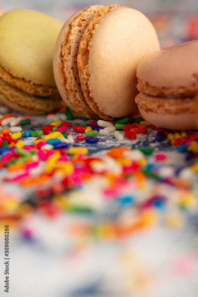 Macro, closeup of colored french macaroons, sweets with colored caramel sweets. Vertical frame.