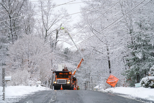 manual worker working on repair electrical line after winter snow storm