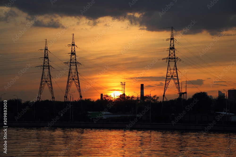 Big masts of an air power line, power grid on beautiful evening Sunset background in Moscow - industrial landscape, enveronment,ecology, traditional energy, electricity, electric power transportation