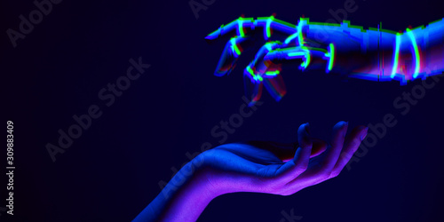 Woman and robot's hands as a symbol of connections between people and technology. Neon colors.