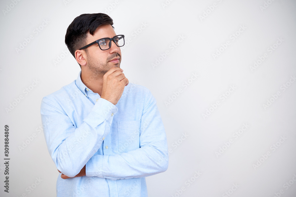 Pensive young entrepreneur in glasses touching chin and looking up, isolated on white Pensive young entrepreneur in glasses touching chin and looking up, isolated on white