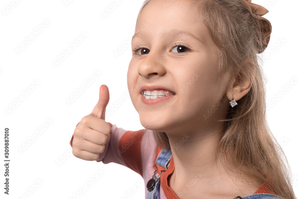 Little girl with orthodontics appliance isolated on white background. Little girl with orthodontics appliance isolated on white background.