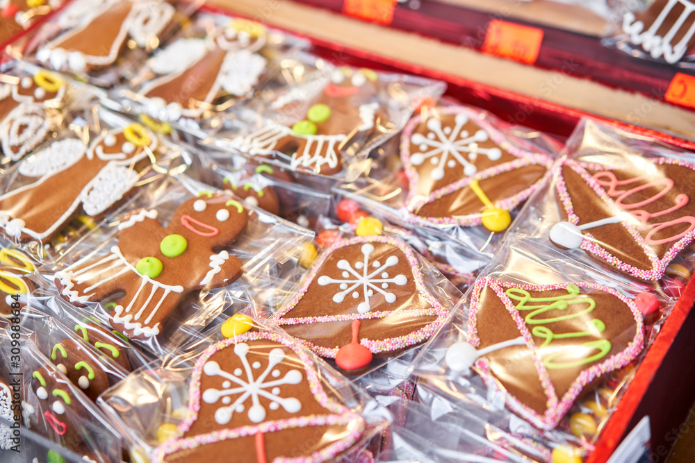 Ginger cookies of different shapes. Gingerbread man and christmas mood in blurred background. Christmas market in old town European small city. Ginger cookies of different shapes. Gingerbread man and christmas mood in blurred background. Christmas market in old town European small city.