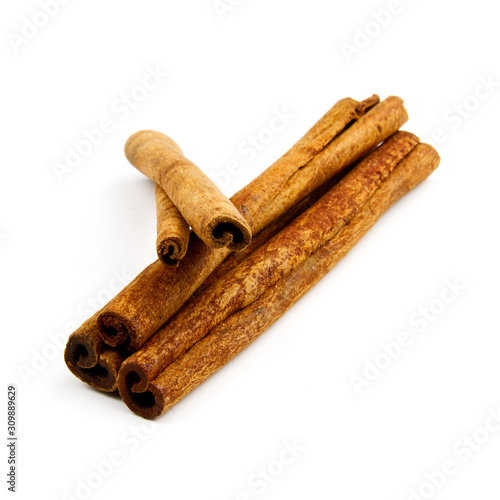 three cinnamon sticks stacked on white background