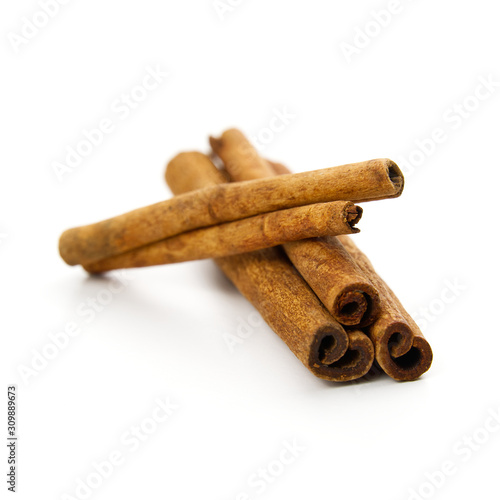 three cinnamon sticks stacked on white background