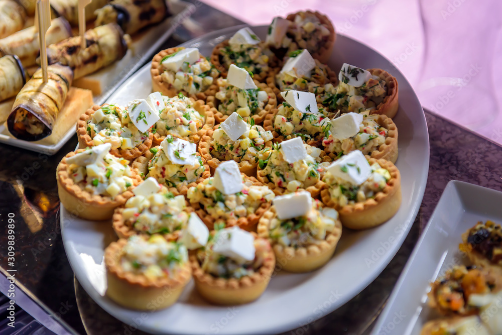 Tartlets with vegetable salad and cheese, close-up. Cold appetizers at restaurant. Tartlets with vegetable salad and cheese, close-up. Cold appetizers at restaurant.