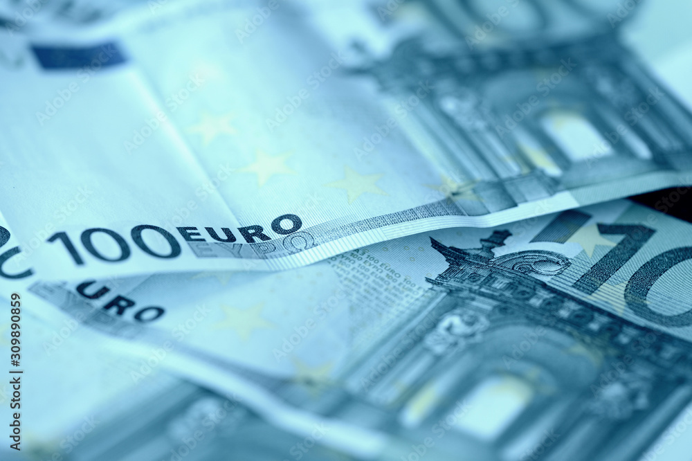 Several hundred euro banknotes close-up. Money background blue color tinted Several hundred euro banknotes close-up. Money background blue color tinted